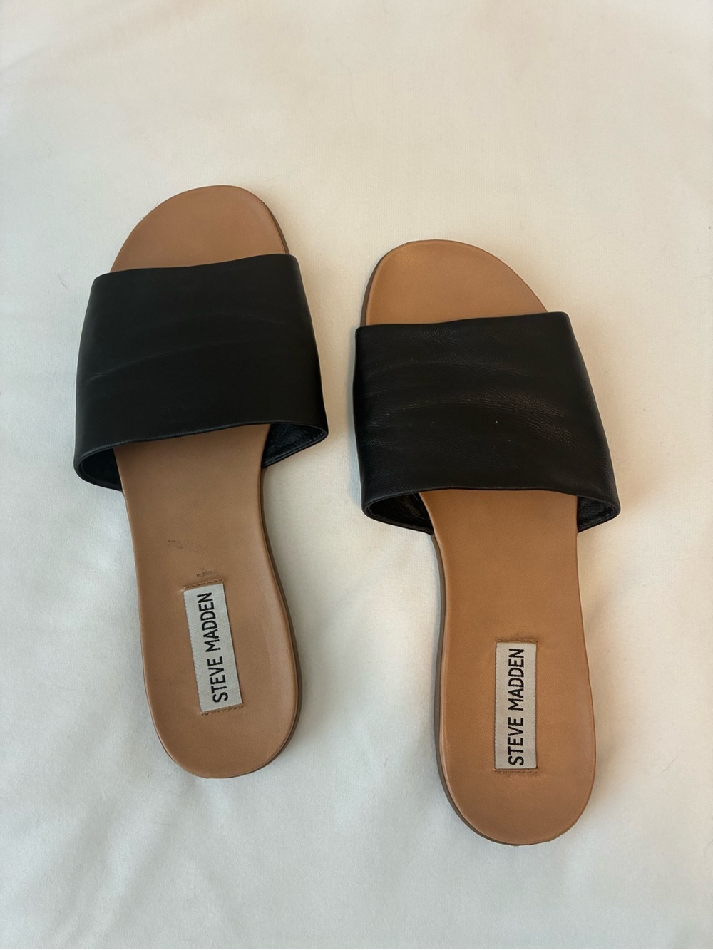Steve Madden Kailey slide sandals, featuring a wide black leather strap.